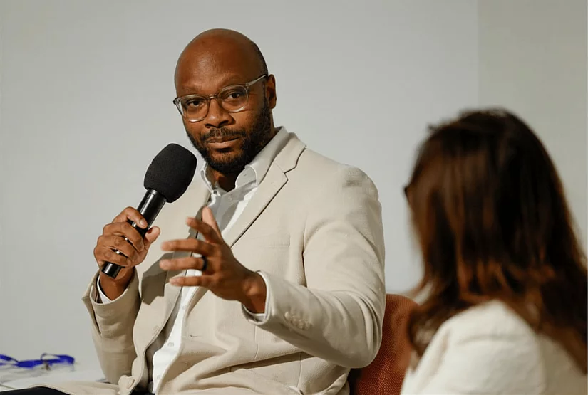 Armand Zorn speaking into microphone during a NSFF panel event in New York, December 2025