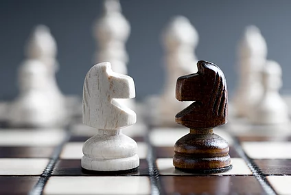 two figures on a chessboard facing each other
